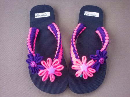 58. VIVAS. Suela negra con tiras en fucsia y morado, y con detalles de flores del mismo color.